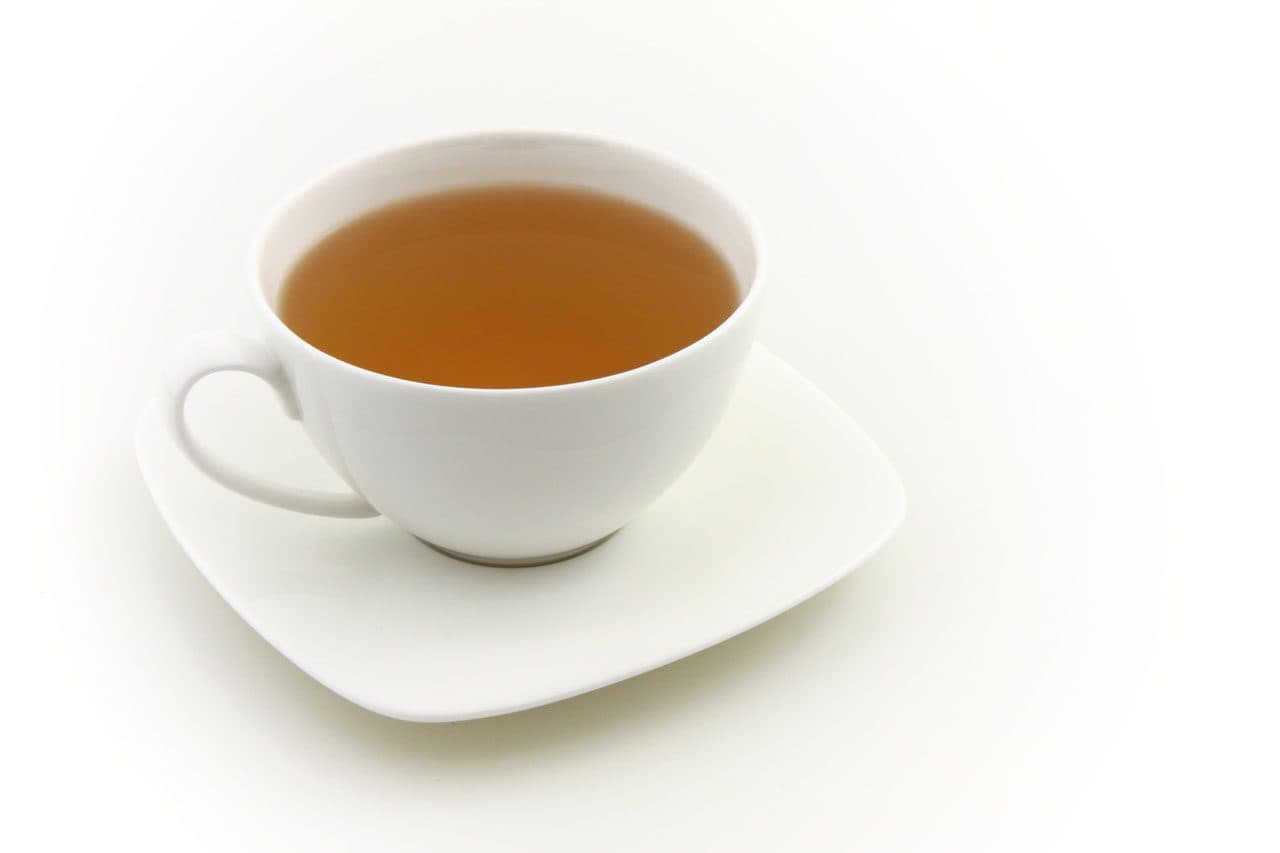 Tasse de thé sur sa soucoupe, photographiée sur fond blanc
